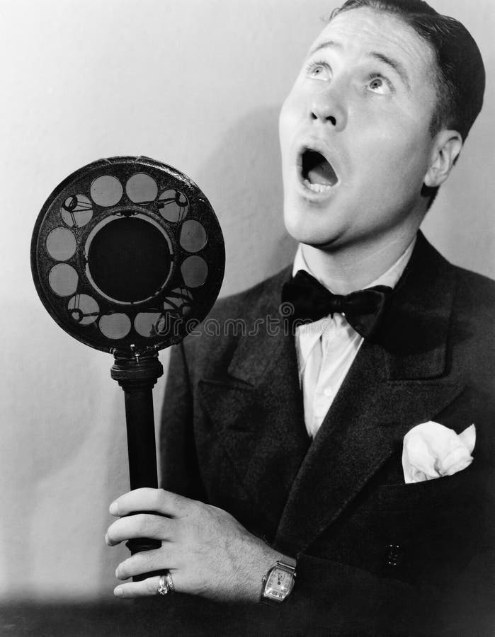 Man singing with radio microphone (All persons depicted are no longer living and no estate exists. Supplier grants that there will be no model release issues.). Man singing with radio microphone (All persons depicted are no longer living and no estate exists. Supplier grants that there will be no model release issues.)