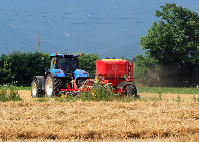 Τρακτέρ με seeder τη μηχανή σε έναν πρόσφατα κομμένο τομέα σίτου στοκ φωτογραφίες Τρακτέρ με seeder τη μηχανή σε έναν πρόσφατα κομμένο τομέα σίτου στοκ φωτογραφίες