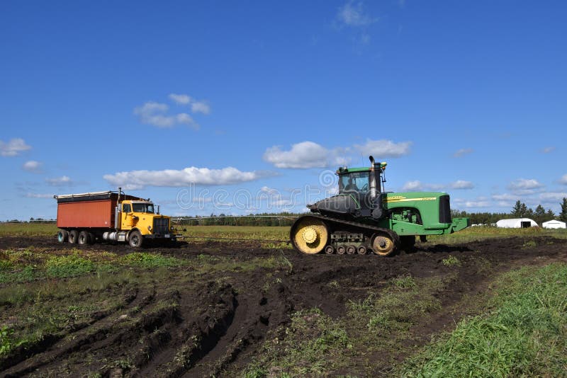 Τρακτέρ του John Deere που τραβά το φορτηγό τεύτλων στη λάσπη στοκ εικόνες Τρακτέρ του John Deere που τραβά το φορτηγό τεύτλων στη λάσπη στοκ εικόνες