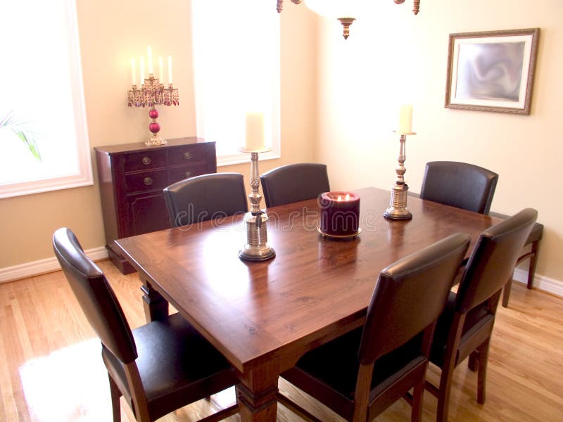 Dining Room with dark wood table, six chairs, candelabra and two windows with a natural wood floor. Dining Room with dark wood table, six chairs, candelabra and two windows with a natural wood floor.