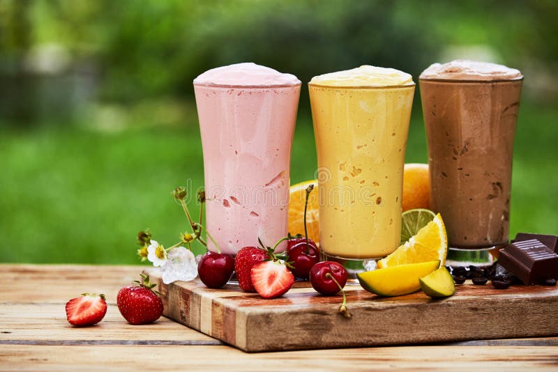 Τρεις εύγευστοι milkshakes και καταφερτζήδες υπαίθρια στοκ εικόνες Τρεις εύγευστοι milkshakes και καταφερτζήδες υπαίθρια στοκ εικόνες