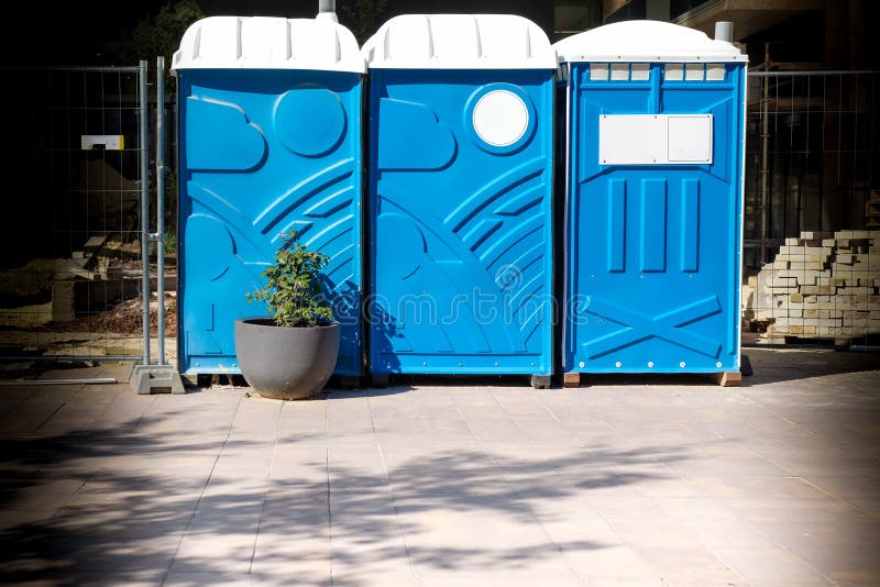 Τρεις φορητές μπλε καμπίνες τουαλέτας WC στο εργοτάξιο στοκ φωτογραφίες με δικαίωμα ελεύθερης χρήσης Τρεις φορητές μπλε καμπίνες τουαλέτας WC στο εργοτάξιο στοκ φωτογραφίες με δικαίωμα ελεύθερης χρήσης
