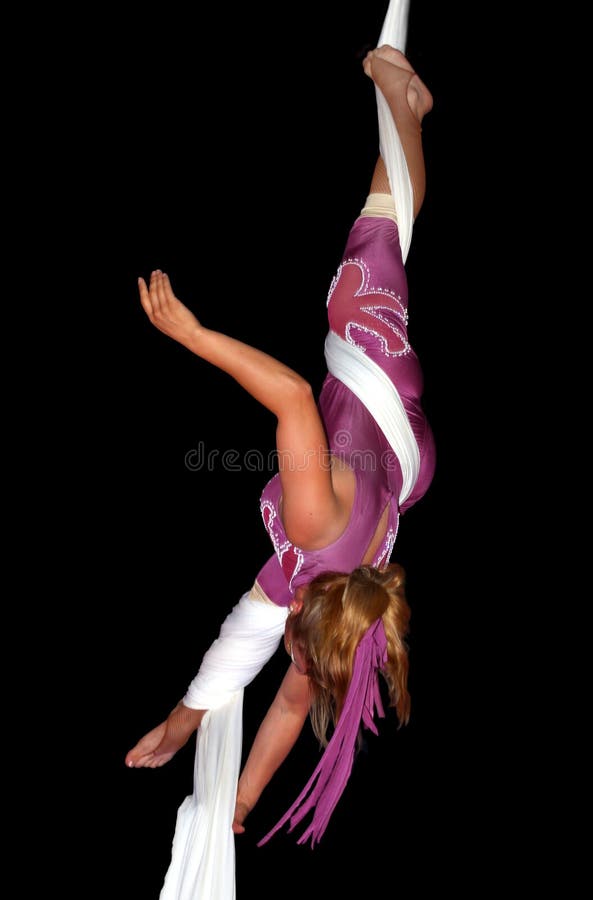 Circus artist performing an acrobatic act over a pure black background. Circus artist performing an acrobatic act over a pure black background