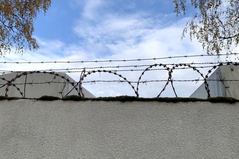 Τσιμεντένιος φράχτης με δακτυλίους από σιδερένιο συρματόπλεγμα στην κορυφή, σύλληψη φυλακής, συμπεράσματα, δέσιμο στοκ εικόνα Τσιμεντένιος φράχτης με δακτυλίους από σιδερένιο συρματόπλεγμα στην κορυφή, σύλληψη φυλακής, συμπεράσματα, δέσιμο στοκ εικόνα
