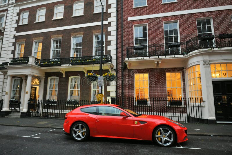 Τυπικό σπίτι στο Mayfair London με κόκκινο αυτοκίνητο συγκομιδής Ferrari στοκ εικόνες