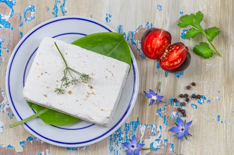 τυρί feta απομονωμένο σε λευκό πηγάδι από φύλλα φέτα βασιλικού και ντομάτες. στοκ εικόνα με δικαίωμα ελεύθερης χρήσης