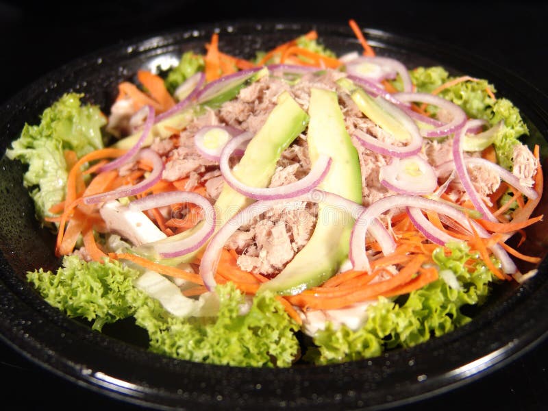 Tuna salad with avocado, fresh lettuce leaves, carrot, onion, olive oil. Tuna salad with avocado, fresh lettuce leaves, carrot, onion, olive oil