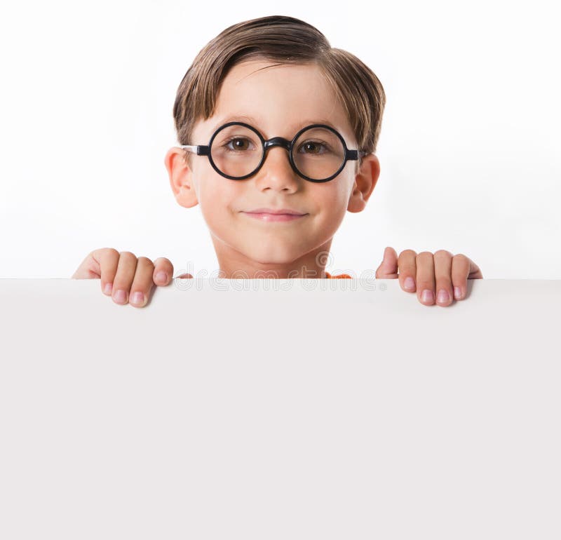 Face of youthful boy in glasses looking from behind white partition. Face of youthful boy in glasses looking from behind white partition