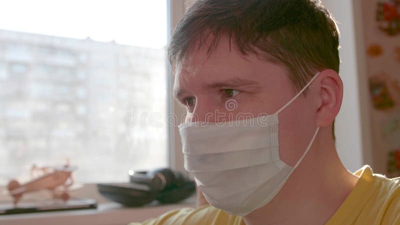 τύπος με προστατευτική μάσκα μένει στο σπίτι σε αυτοαπομόνωση. πρόληψη και προστασία της υγείας και της ασφάλειας ζωής.