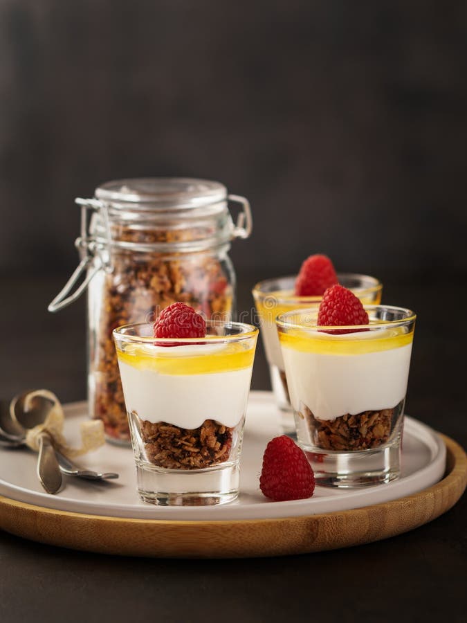 Υγιές φρέσκο granola προγευμάτων, muesli σε ένα γυαλί με τα ξύλα καρυδιάς γιαουρτιού, τα μούρα goji και τα σμέουρα στο σκοτεινό υ στοκ εικόνα Υγιές φρέσκο granola προγευμάτων, muesli σε ένα γυαλί με τα ξύλα καρυδιάς γιαουρτιού, τα μούρα goji και τα σμέουρα στο σκοτεινό υ στοκ εικόνα