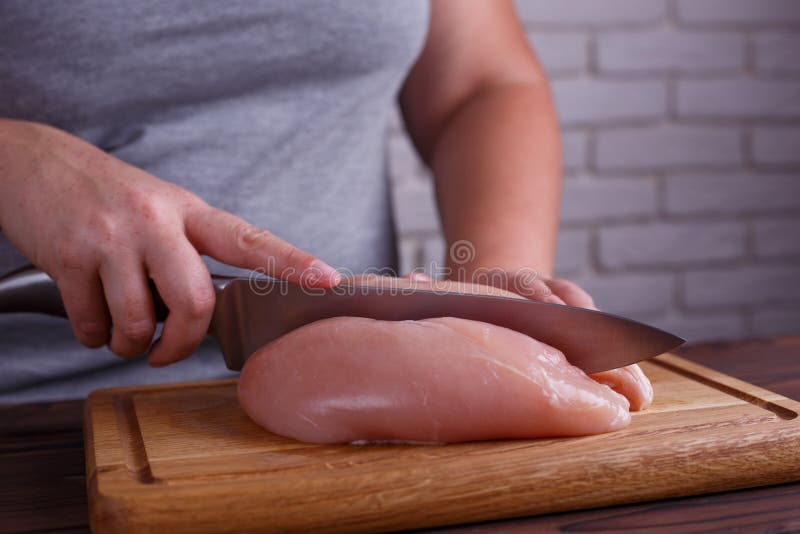 Υπέρβαρα χέρια γυναικών που τεμαχίζουν επάνω στα στήθη κοτόπουλου Να κάνει δίαιτα, αυτός στοκ εικόνες με δικαίωμα ελεύθερης χρήσης Υπέρβαρα χέρια γυναικών που τεμαχίζουν επάνω στα στήθη κοτόπουλου Να κάνει δίαιτα, αυτός στοκ εικόνες με δικαίωμα ελεύθερης χρήσης