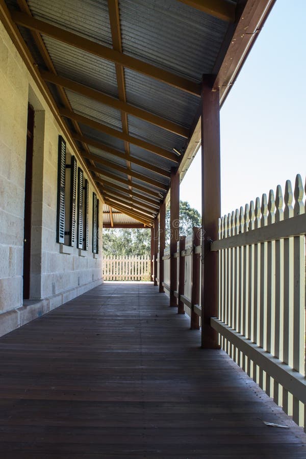 Υπαίθρια γέφυρα patio βεραντών του εξοχικού σπιτιού τούβλου ψαμμίτη με το φράκτη στύλων στην ηλιοφάνεια στοκ φωτογραφία με δικαίωμα ελεύθερης χρήσης