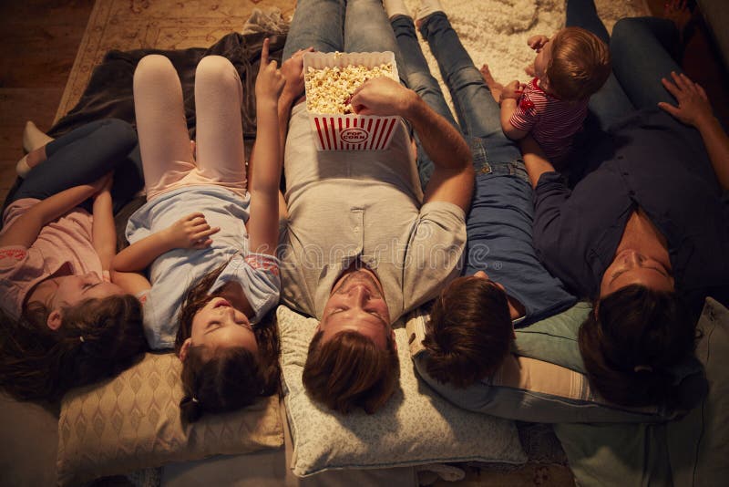 Overhead View Of Family Enjoying Movie Night At Home Together. Overhead View Of Family Enjoying Movie Night At Home Together