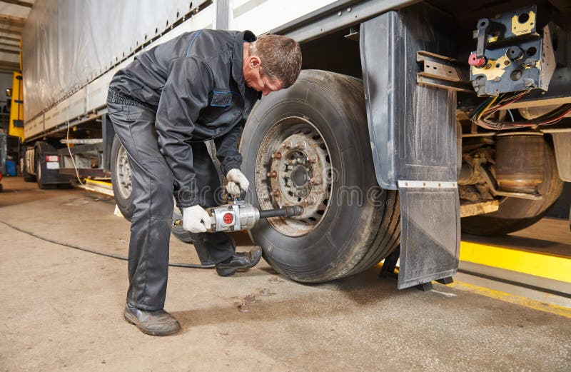 Truck repair service. Mechanic takes off tyre for wheel replacement. Truck repair service. Mechanic takes off tyre for wheel replacement