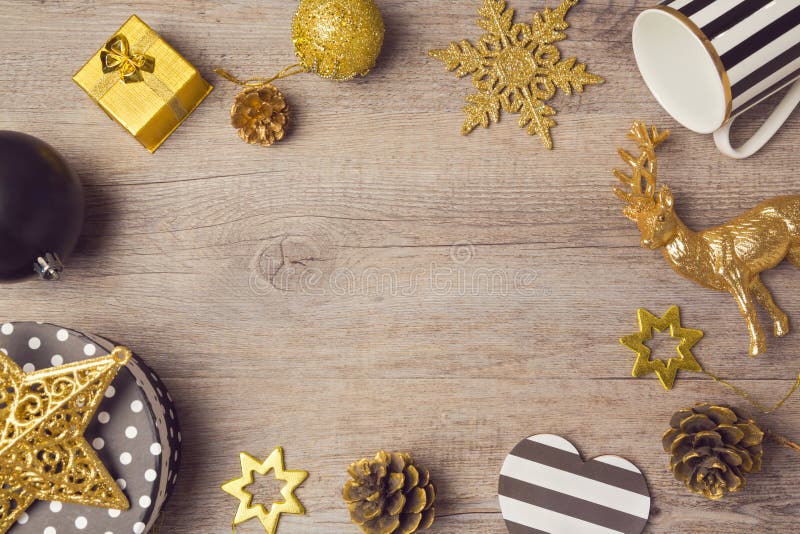 Υπόβαθρο Χριστουγέννων με τις σύγχρονες μαύρες και χρυσές διακοσμήσεις στον ξύλινο πίνακα επάνω από την όψη στοκ εικόνα