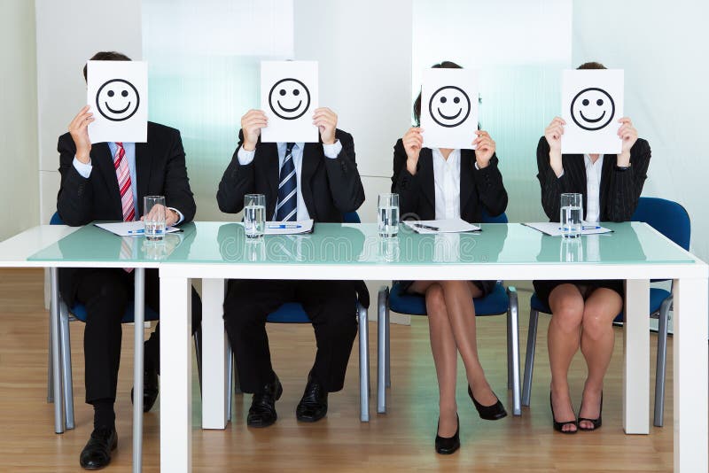 Row of business executives with smiley faces in front of their faces. Row of business executives with smiley faces in front of their faces