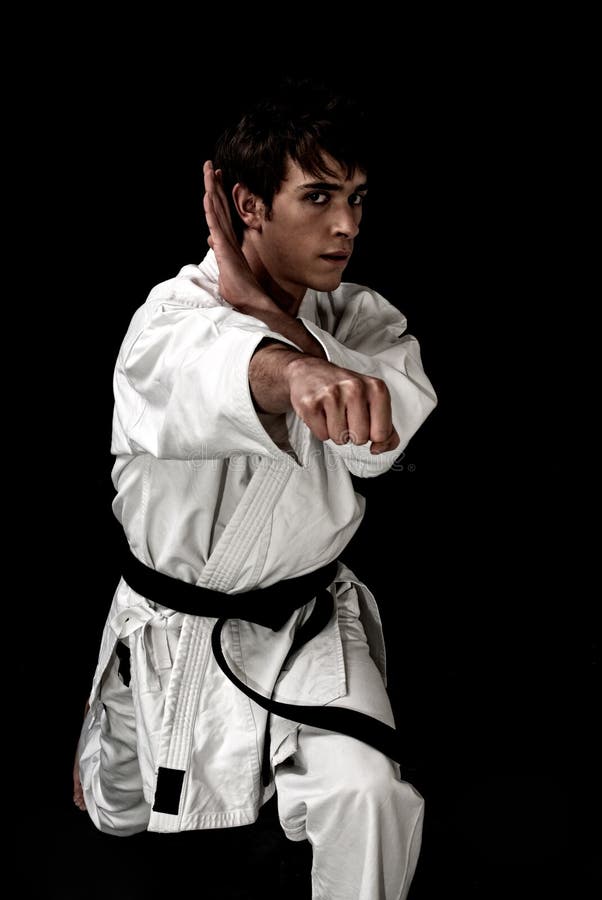 Υψηλός karate αντίθεσης νέος αρσενικός μαχητής στο Μαύρο στοκ φωτογραφίες