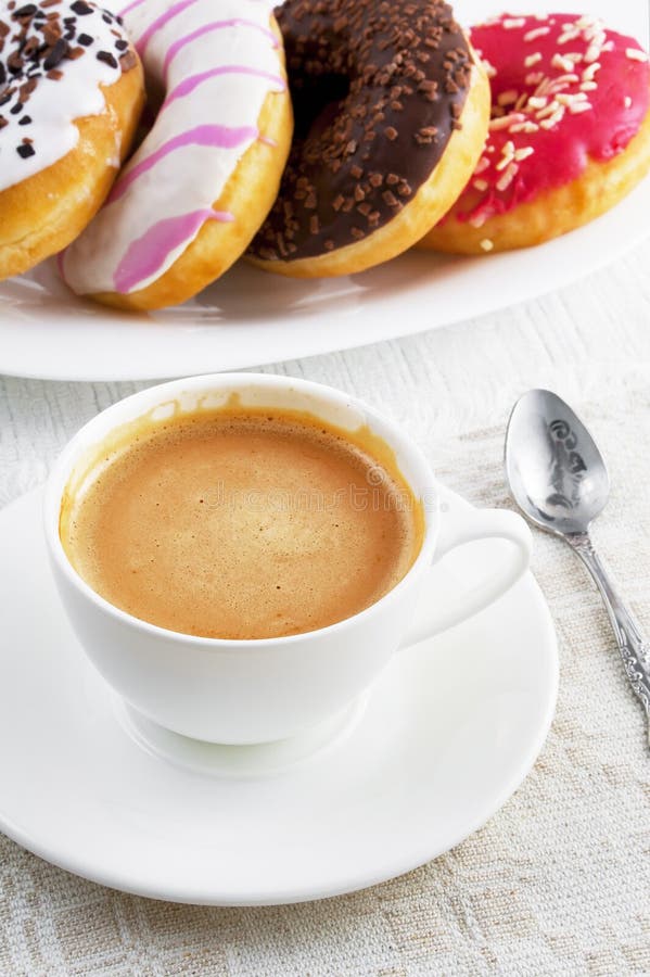 Φλιτζάνι του καφέ και donuts σε ένα πιάτο στοκ εικόνες με δικαίωμα ελεύθερης χρήσης Φλιτζάνι του καφέ και donuts σε ένα πιάτο στοκ εικόνες με δικαίωμα ελεύθερης χρήσης