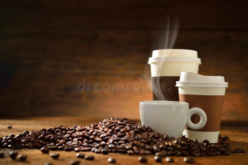 Cups of coffee with smoke and coffee beans on old wooden background. Cups of coffee with smoke and coffee beans on old wooden background