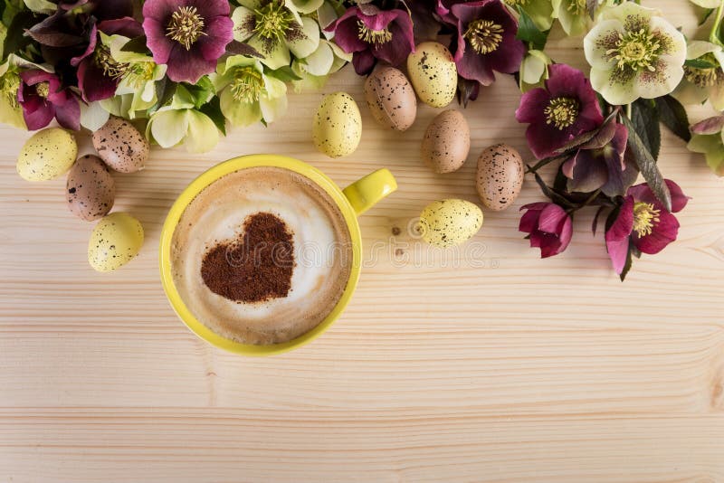 Φλυτζάνι Cappuccino καφέ με τη διακόσμηση Πάσχας στον ελαφρύ ξύλινο πίνακα Αφρός μορφής καρδιών, τοπ άποψη στοκ φωτογραφίες