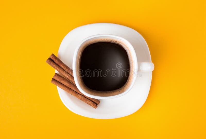 Cup of fresh espresso with cinnamon on yellow background, view from above. Cup of fresh espresso with cinnamon on yellow background, view from above