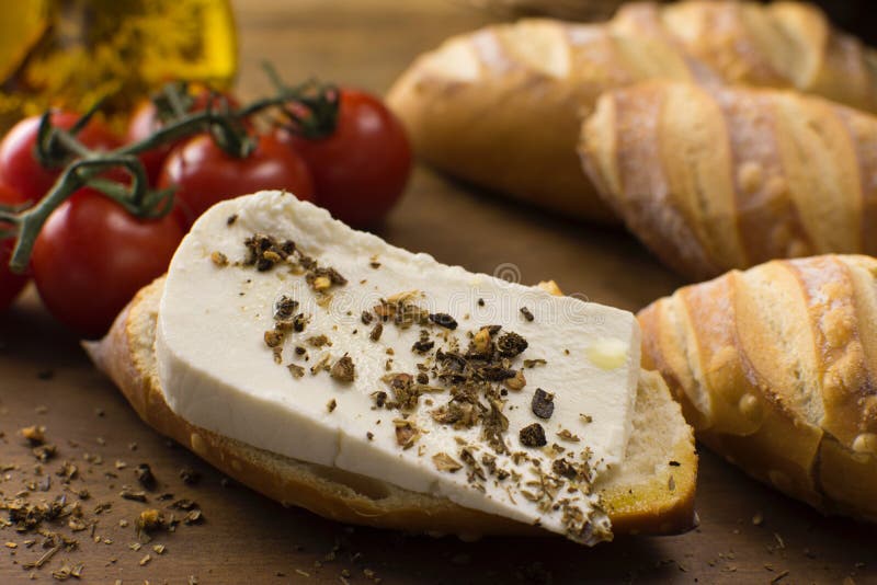 φέτα βουβάλου νωπό τυρί που παρασκευάζεται σε serra da canstra με ιταλικό ψωμί σε ξύλινο φόντο κοντά στο μισό φως στοκ εικόνα