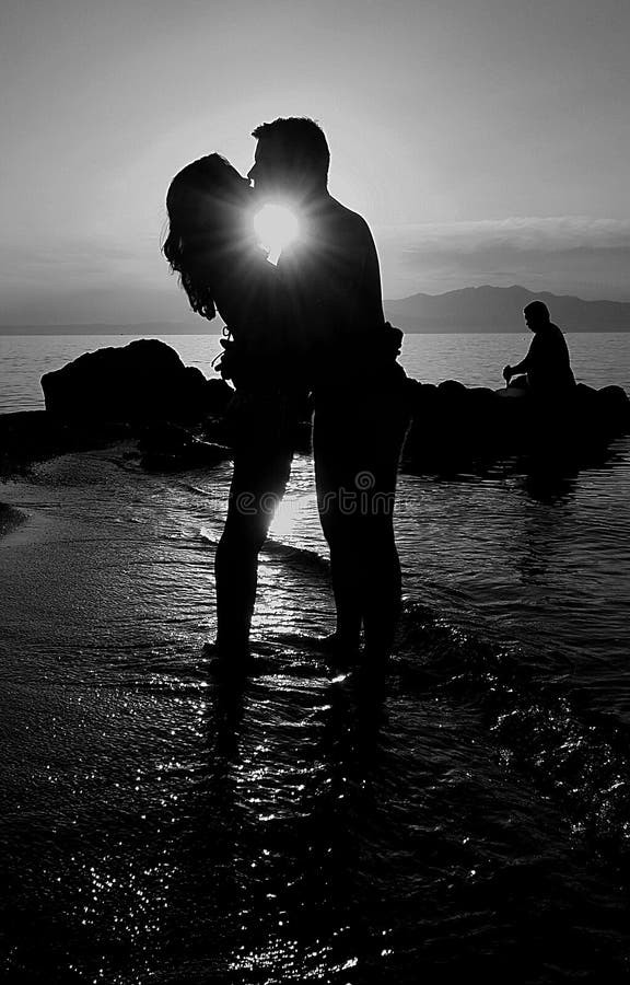 Φίλημα ζεύγους στην ωκεάνια παραλία στο ηλιοβασίλεμα στοκ φωτογραφία με δικαίωμα ελεύθερης χρήσης Φίλημα ζεύγους στην ωκεάνια παραλία στο ηλιοβασίλεμα στοκ φωτογραφία με δικαίωμα ελεύθερης χρήσης