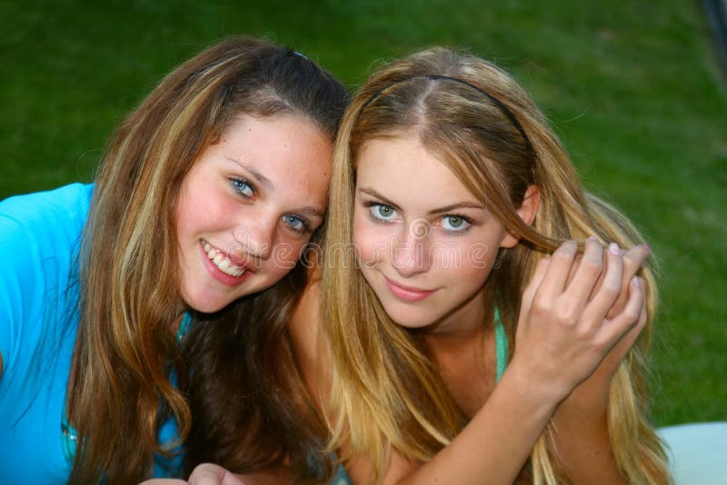 Two teenage girls, gossiping outside. Two teenage girls, gossiping outside.