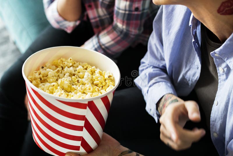 Friends enjoying a movie on Friday night with popcorn. Friends enjoying a movie on Friday night with popcorn