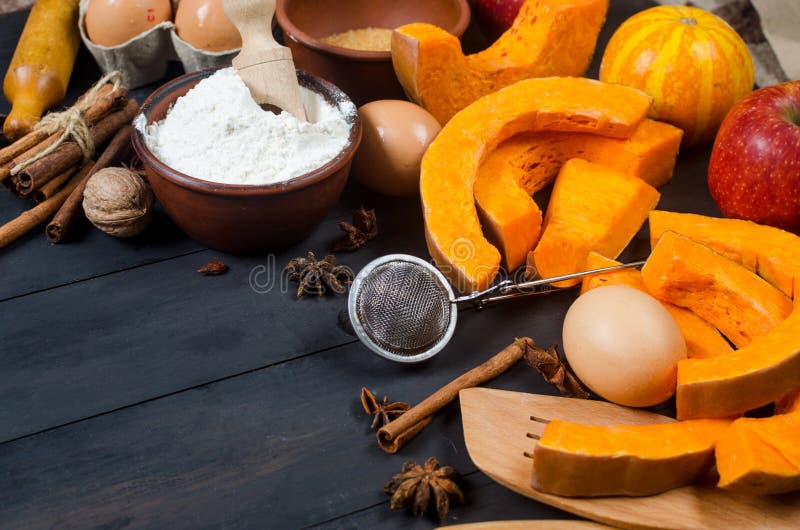 Autumn baking concept. Frame with pumpkin, apple, nuts, cinamon, egg and flour on the wood table. Cooking baking process with ingredients. top view. copy space. Autumn baking concept. Frame with pumpkin, apple, nuts, cinamon, egg and flour on the wood table. Cooking baking process with ingredients. top view. copy space