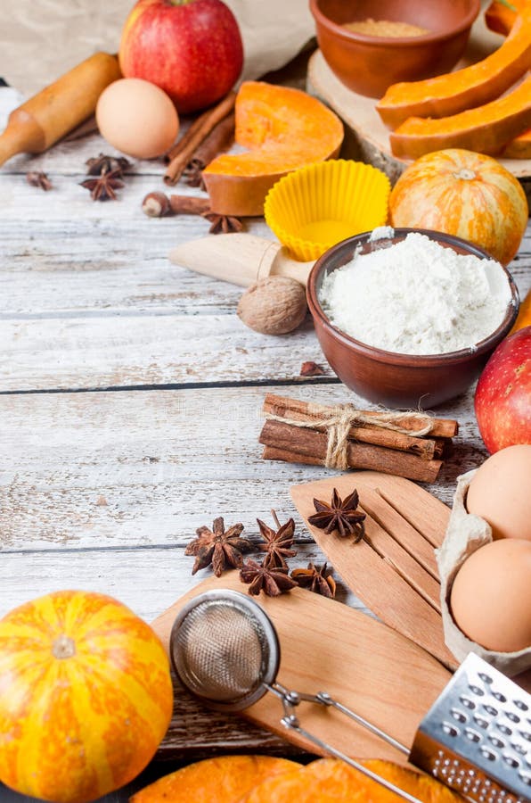 Autumn baking concept. Frame with pumpkin, apple, nuts, cinamon, egg and flour on the wood table. Cooking baking process with ingredients. top view. copy space,. Autumn baking concept. Frame with pumpkin, apple, nuts, cinamon, egg and flour on the wood table. Cooking baking process with ingredients. top view. copy space,