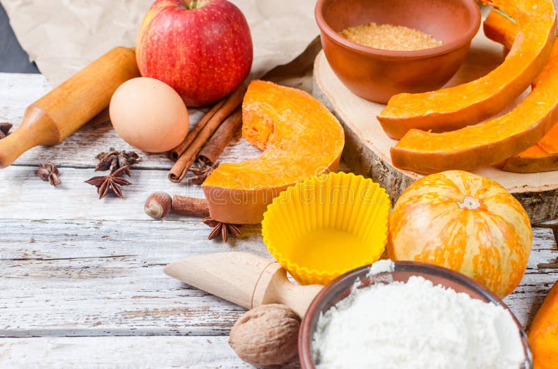 Autumn baking concept. Frame with pumpkin, apple, nuts, cinamon, egg and flour on the wood table. Cooking baking process with ingredients. top view. copy space,. Autumn baking concept. Frame with pumpkin, apple, nuts, cinamon, egg and flour on the wood table. Cooking baking process with ingredients. top view. copy space,