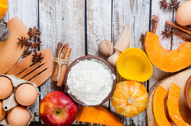 Autumn baking concept. Frame with pumpkin, apple, nuts, cinamon, egg and flour on the wood table. Cooking baking process with ingredients. top view. copy space,. Autumn baking concept. Frame with pumpkin, apple, nuts, cinamon, egg and flour on the wood table. Cooking baking process with ingredients. top view. copy space,