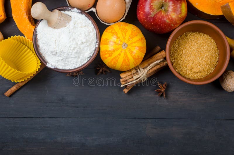 Autumn baking concept. Frame with pumpkin, apple, nuts, cinamon, egg and flour on the wood table. Cooking baking process with ingredients. top view. copy space. Autumn baking concept. Frame with pumpkin, apple, nuts, cinamon, egg and flour on the wood table. Cooking baking process with ingredients. top view. copy space