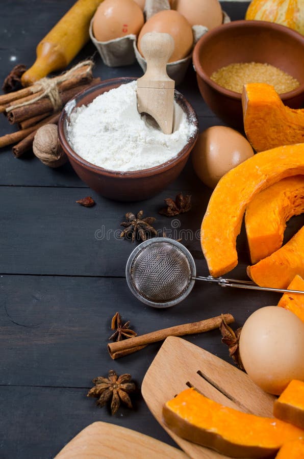 Autumn baking concept. Frame with pumpkin, apple, nuts, cinamon, egg and flour on the wood table. Cooking baking process with ingredients. top view. copy space. Autumn baking concept. Frame with pumpkin, apple, nuts, cinamon, egg and flour on the wood table. Cooking baking process with ingredients. top view. copy space