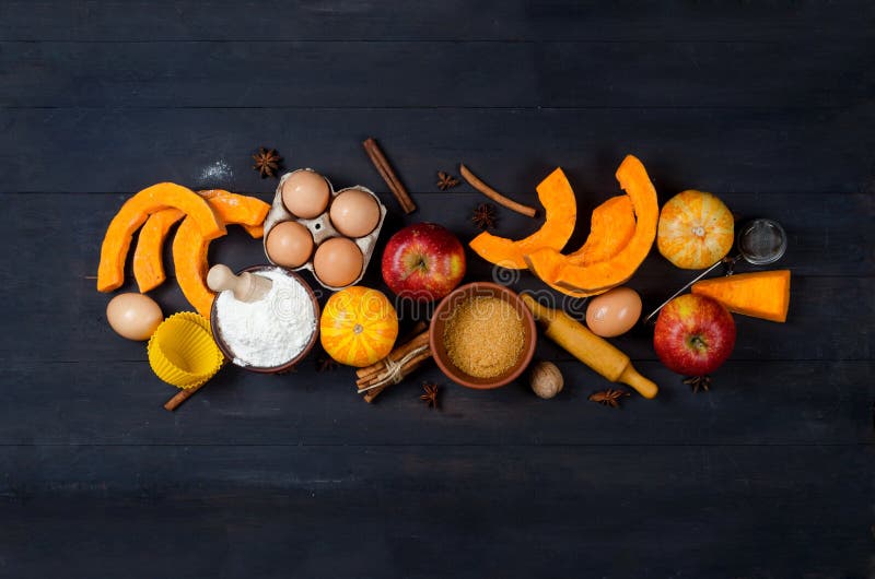 Autumn baking concept. Frame with pumpkin, apple, nuts, cinamon, egg and flour on the wood table. Cooking baking process with ingredients. top view. copy space. Autumn baking concept. Frame with pumpkin, apple, nuts, cinamon, egg and flour on the wood table. Cooking baking process with ingredients. top view. copy space