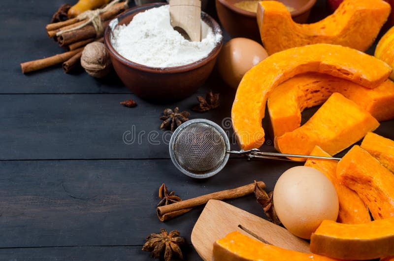 Autumn baking concept. Frame with pumpkin, apple, nuts, cinamon, egg and flour on the wood table. Cooking baking process with ingredients. top view. copy space. Autumn baking concept. Frame with pumpkin, apple, nuts, cinamon, egg and flour on the wood table. Cooking baking process with ingredients. top view. copy space