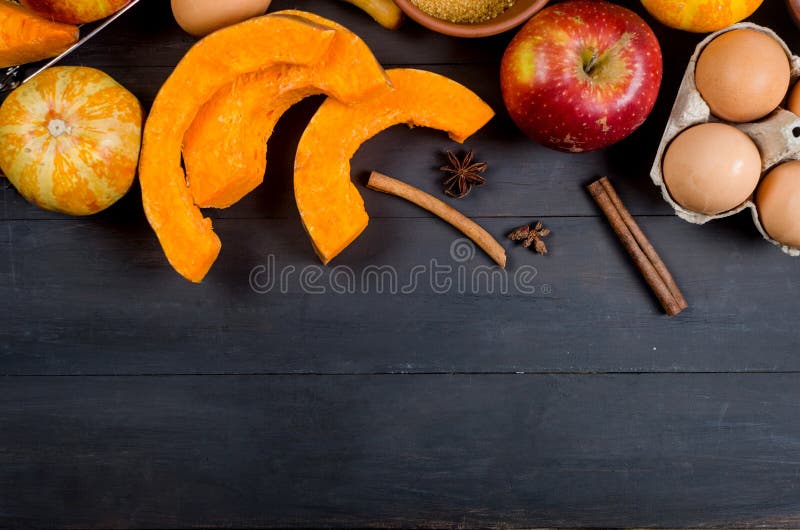 Autumn baking concept. Frame with pumpkin, apple, nuts, cinamon, egg and flour on the wood table. Cooking baking process with ingredients. top view. copy space. Autumn baking concept. Frame with pumpkin, apple, nuts, cinamon, egg and flour on the wood table. Cooking baking process with ingredients. top view. copy space