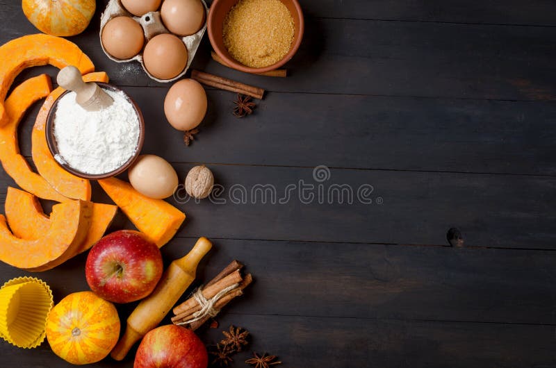 Autumn baking concept. Frame with pumpkin, apple, nuts, cinamon, egg and flour on the wood table. Cooking baking process with ingredients. top view. copy space. Autumn baking concept. Frame with pumpkin, apple, nuts, cinamon, egg and flour on the wood table. Cooking baking process with ingredients. top view. copy space