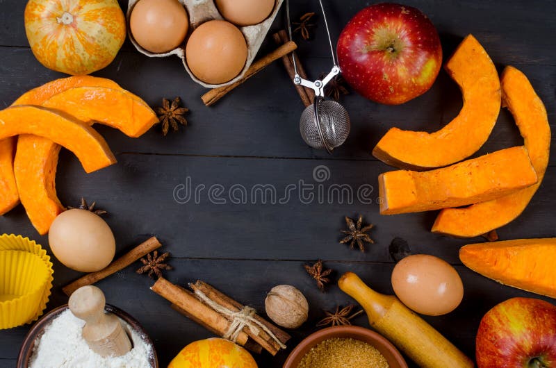 Autumn baking concept. Frame with pumpkin, apple, nuts, cinamon, egg and flour on the wood table. Cooking baking process with ingredients. top view. copy space. Autumn baking concept. Frame with pumpkin, apple, nuts, cinamon, egg and flour on the wood table. Cooking baking process with ingredients. top view. copy space