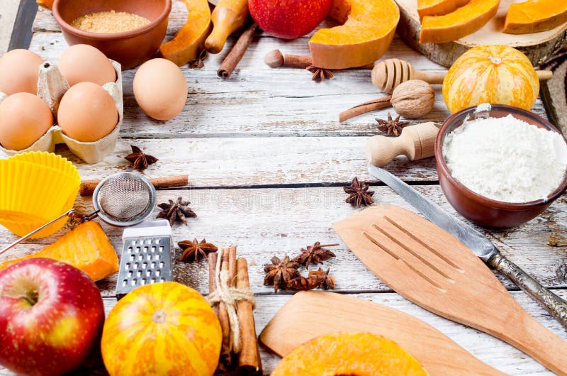 Autumn baking concept. Frame with pumpkin, apple, nuts, cinamon, egg and flour on the wood table. Cooking baking process with ingredients. top view. copy space. Autumn baking concept. Frame with pumpkin, apple, nuts, cinamon, egg and flour on the wood table. Cooking baking process with ingredients. top view. copy space