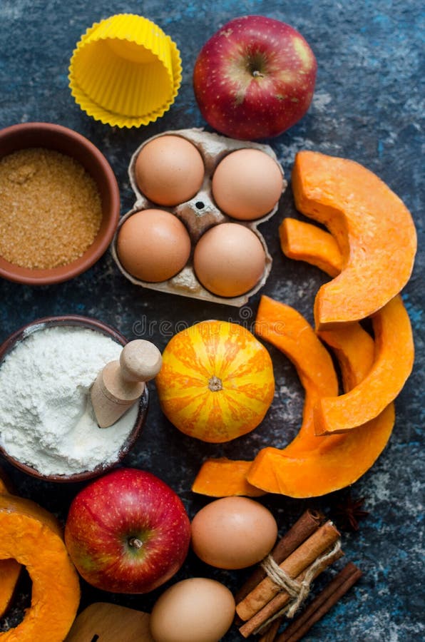 Autumn baking concept. Frame with pumpkin, apple, nuts, cinamon, egg and flour on the wood table. Cooking baking process with ingredients. top view. copy space. Autumn baking concept. Frame with pumpkin, apple, nuts, cinamon, egg and flour on the wood table. Cooking baking process with ingredients. top view. copy space