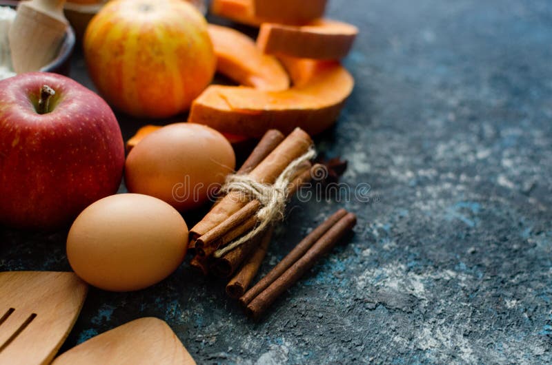 Autumn baking concept. Frame with pumpkin, apple, nuts, cinamon, egg and flour on the wood table. Cooking baking process with ingredients. top view. copy space. Autumn baking concept. Frame with pumpkin, apple, nuts, cinamon, egg and flour on the wood table. Cooking baking process with ingredients. top view. copy space