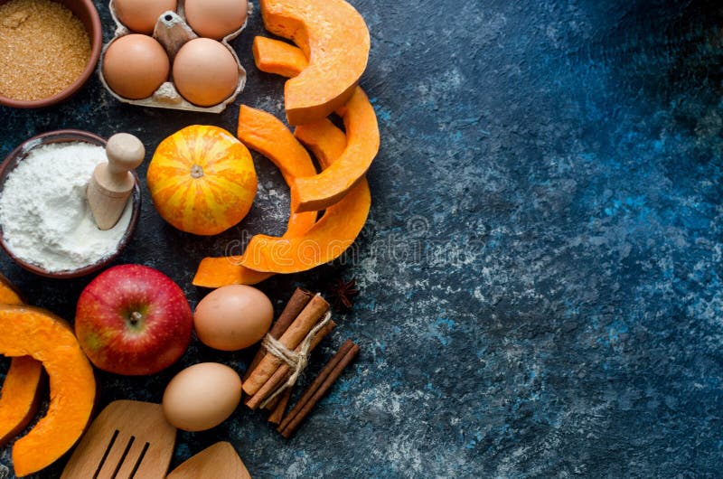 Autumn baking concept. Frame with pumpkin, apple, nuts, cinamon, egg and flour on the wood table. Cooking baking process with ingredients. top view. copy space. Autumn baking concept. Frame with pumpkin, apple, nuts, cinamon, egg and flour on the wood table. Cooking baking process with ingredients. top view. copy space