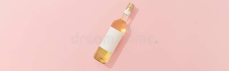 φιάλη κρασιού με κενή ετικέτα. λευκό κρασί σε ροζ φόντο με διάστημα αντιγραφής στοκ εικόνες