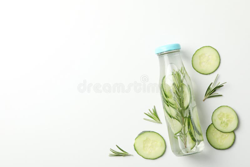 Bottle with infused cucumber water on white background, space for text. Bottle with infused cucumber water on white background, space for text