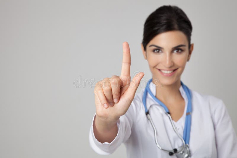 Φιλικός χαμογελώντας γιατρός που δείχνει το δάχτυλό της στο copyspace