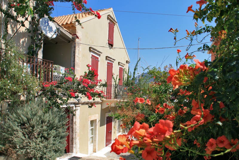 ΦΙΣΚΆΡΔΟ, KEFALONIA, ΕΛΛΆΔΑ - 7 ΣΕΠΤΕΜΒΡΊΟΥ 2012: Σπίτι με τα λουλούδια στο χωριό του Φισκάρδο, Kefalonia στοκ φωτογραφία με δικαίωμα ελεύθερης χρήσης ΦΙΣΚΆΡΔΟ, KEFALONIA, ΕΛΛΆΔΑ - 7 ΣΕΠΤΕΜΒΡΊΟΥ 2012: Σπίτι με τα λουλούδια στο χωριό του Φισκάρδο, Kefalonia στοκ φωτογραφία με δικαίωμα ελεύθερης χρήσης