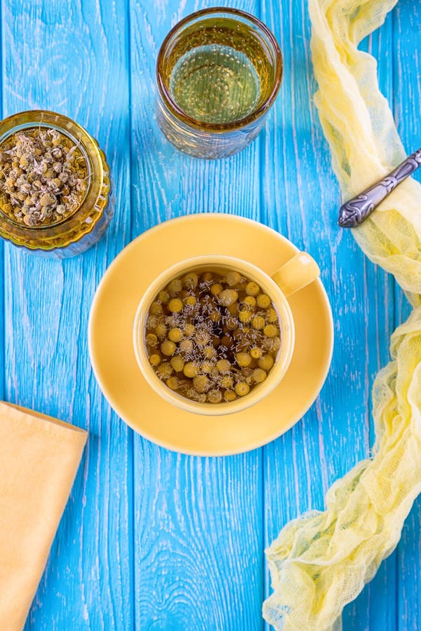 Φλυτζάνι του chamomile τσαγιού και των ξηρών chamomile λουλουδιών σε ένα μπλε υπόβαθρο Τοπ όψη στοκ εικόνες Φλυτζάνι του chamomile τσαγιού και των ξηρών chamomile λουλουδιών σε ένα μπλε υπόβαθρο Τοπ όψη στοκ εικόνες