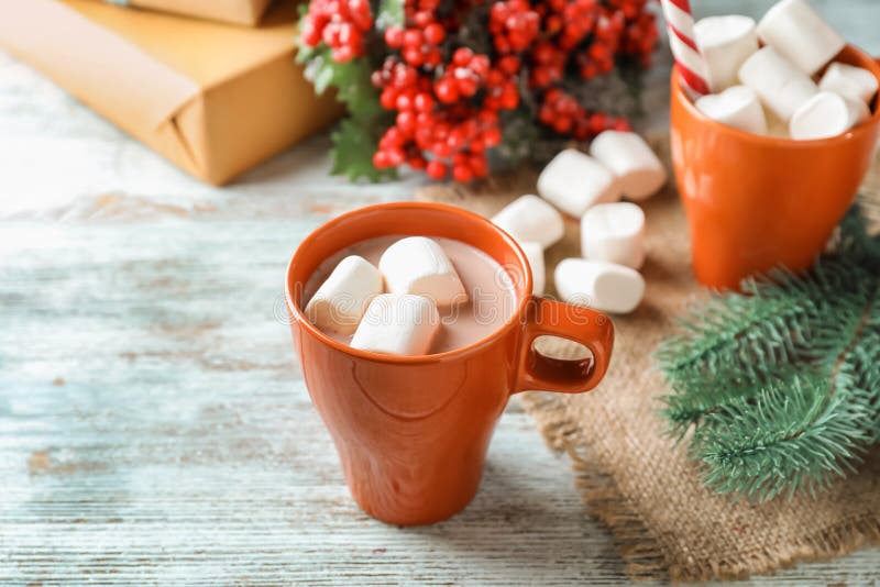 Φλυτζάνια του νόστιμων κακάου, marshmallows και του ντεκόρ Χριστουγέννων στο ξύλινο υπόβαθρο στοκ εικόνες